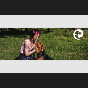 A brown dog next to a kneeling person, looking at each other, sharing a calm moment