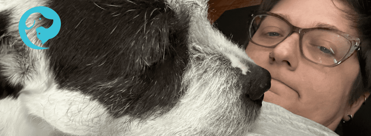 A scruffy white and dark grey dog with his face very close to his person's face. Sometimes you need a break from your dog.