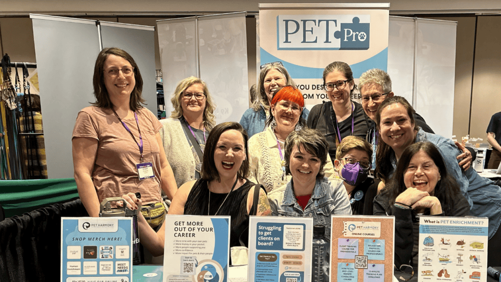 A group of people at a table with a PETPro banner in the background. Professional mentorship with the Practice of Enrichment and Training for Professionals (PETPro).