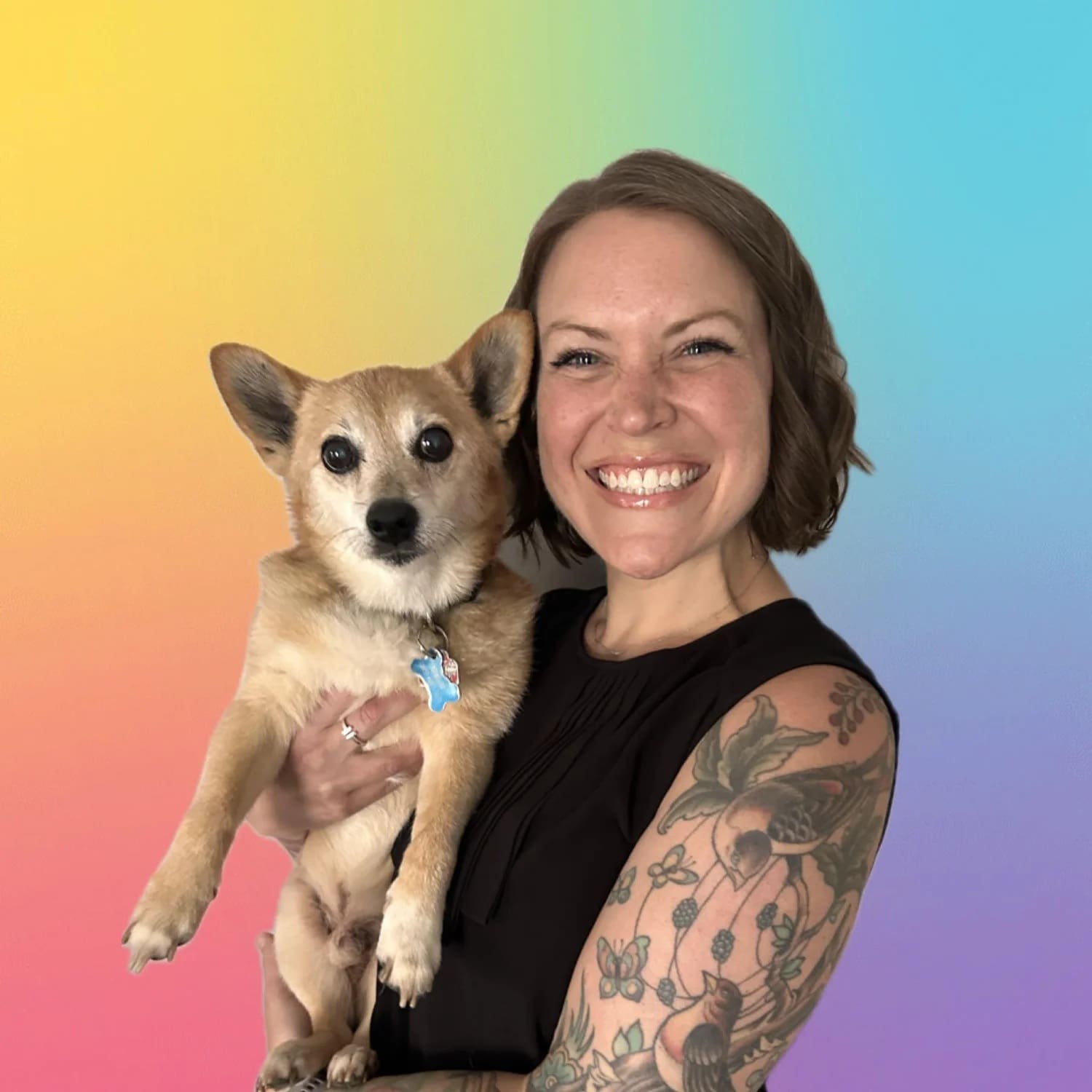A woman holding a small dog with a rainbow background. Valerie Bogie, Veterinary Social Worker.