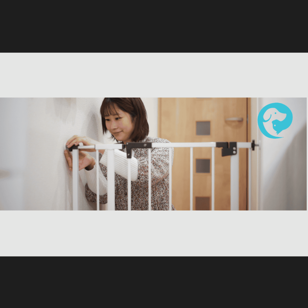 A woman installing a baby gate. Preparing home for dog and baby.